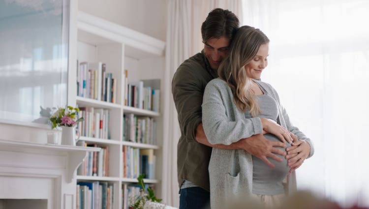 Gravid kvinde og mand i omfavnelse